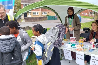 Two students plus staff and children at an event